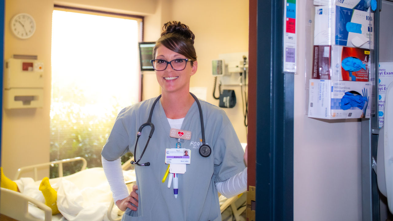 Nurse standing in hospital room with stethoscope