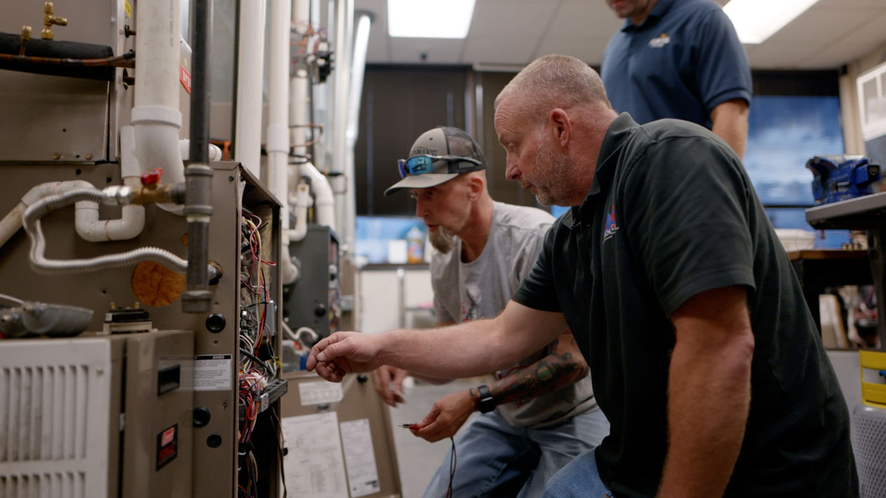 Technicians Repair HVAC System in Workshop Setting